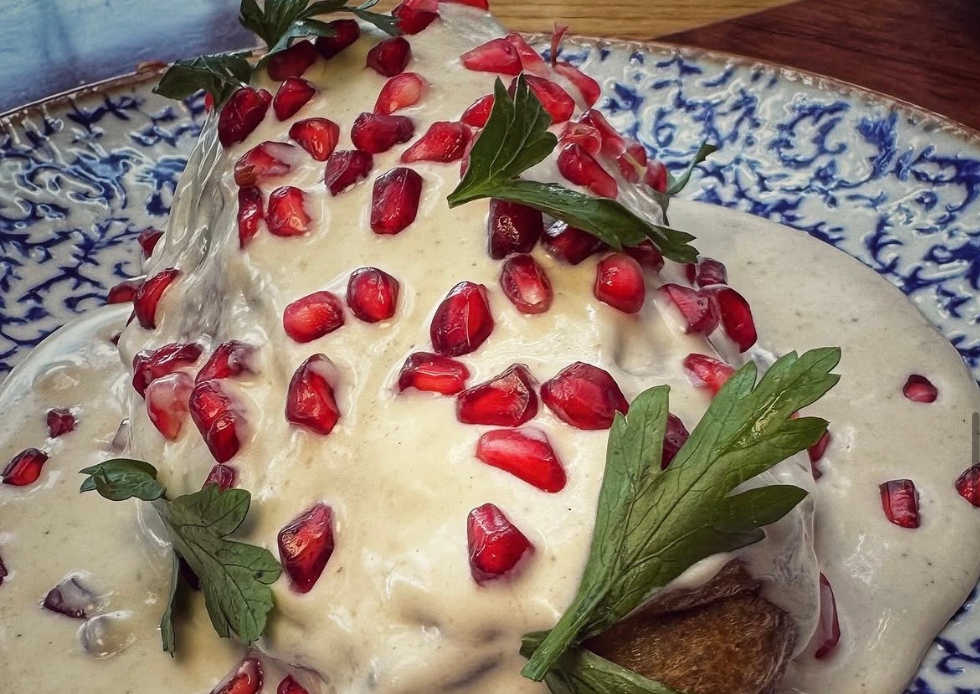 Chile en nogada cubierto con salsa de nuez, granada y perejil para las Fiestas Patrias en Chapulín.