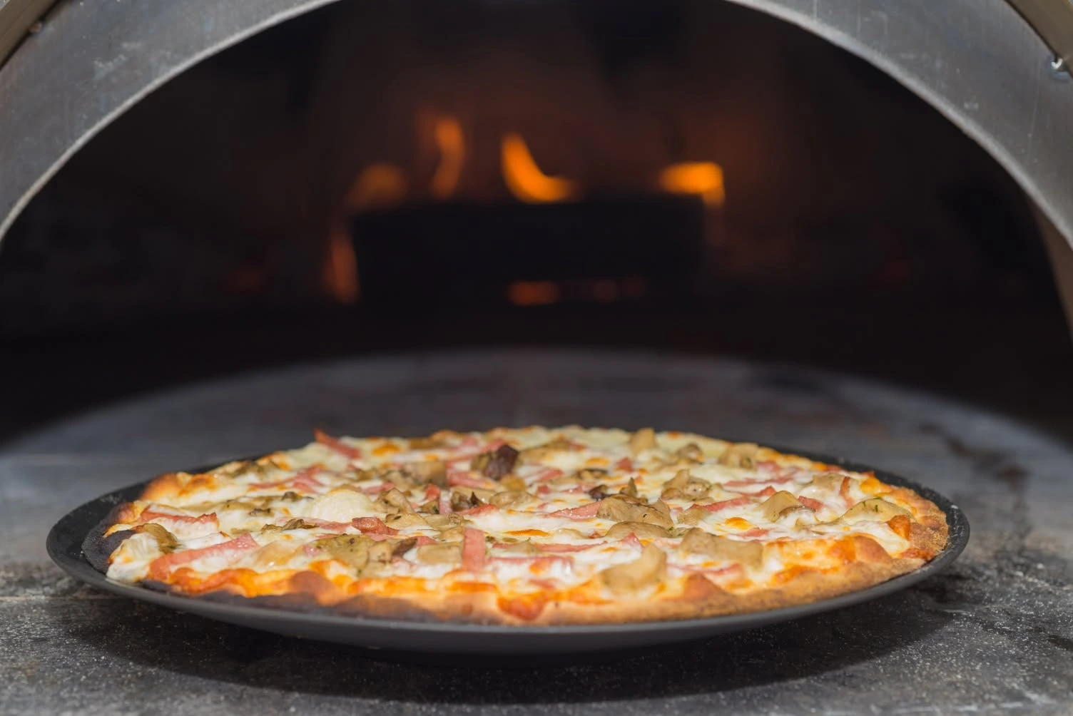 Pizza tradicional cocinada en horno de piedra